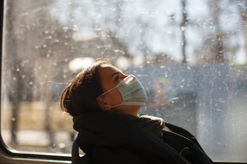 caucasian female with medical mask in urban transport