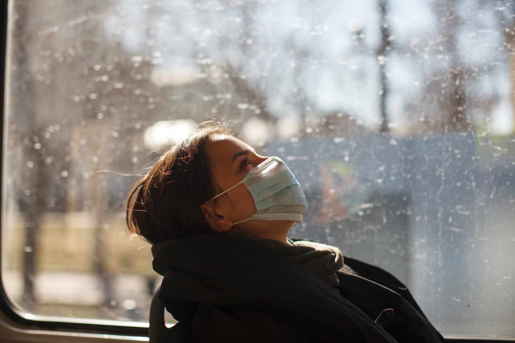 caucasian female with medical mask in urban transport